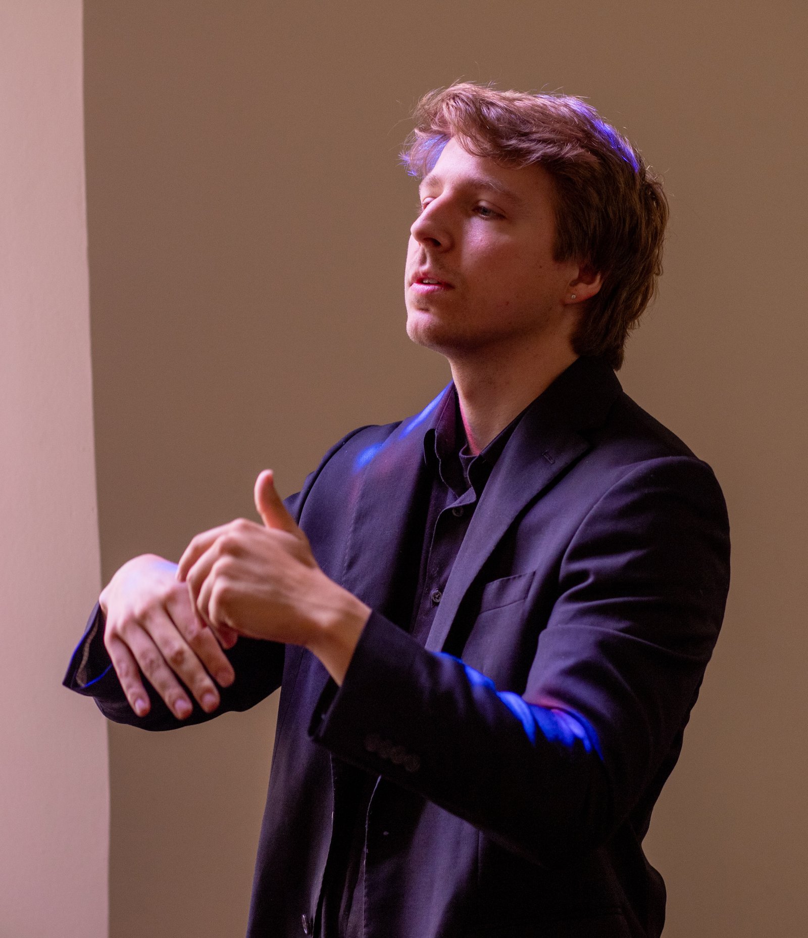Brennan Plummer conducting, hands poised mid-phrase